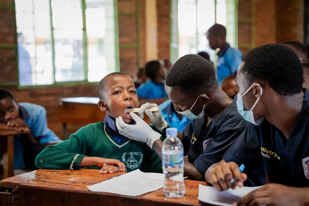 A volunteer dentist checks a schoolboy’s teeth during a free screening