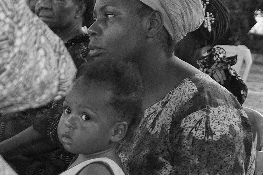 A mother holding her young child at a community gathering